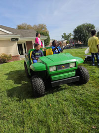 Children driving around in an electric John Deere jeep